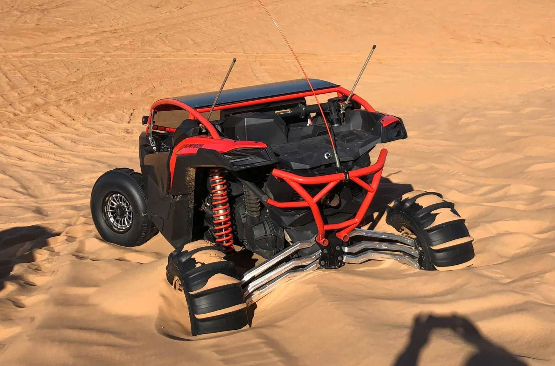 Red off-road side-by-side on a sandy dune