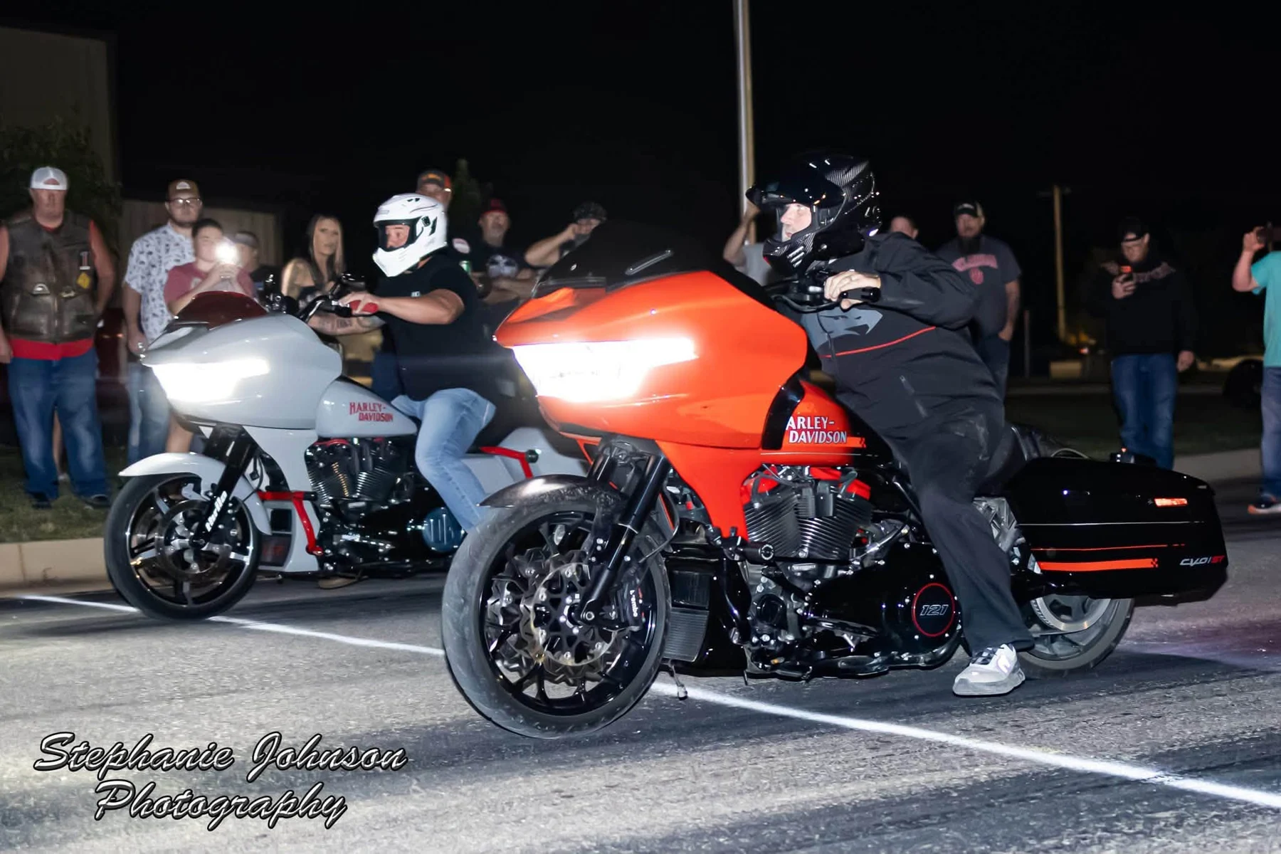 Custom orange and silver touring motorcycles at a nighttime motorcycle event