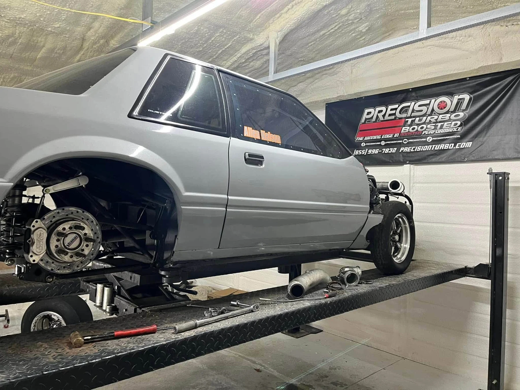 Silver Mustang on a workshop vehicle platform